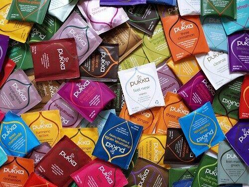 Assorted Pukka tea packets in various colors and designs.