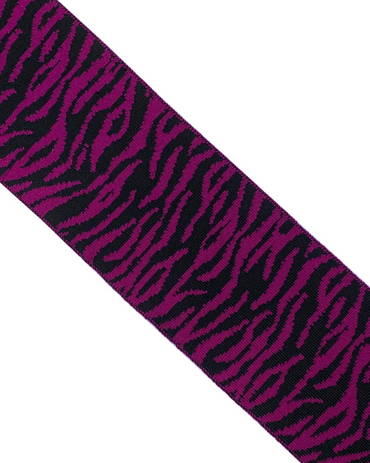 Strip of fabric with purple and black zebra pattern on a white background