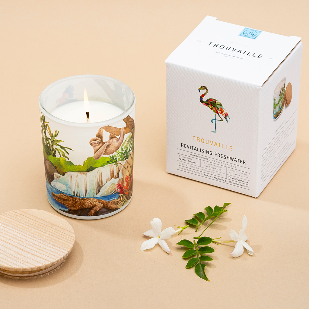 Candle with nature-themed design, with a sloth and crocodile, lid and box on a beige background