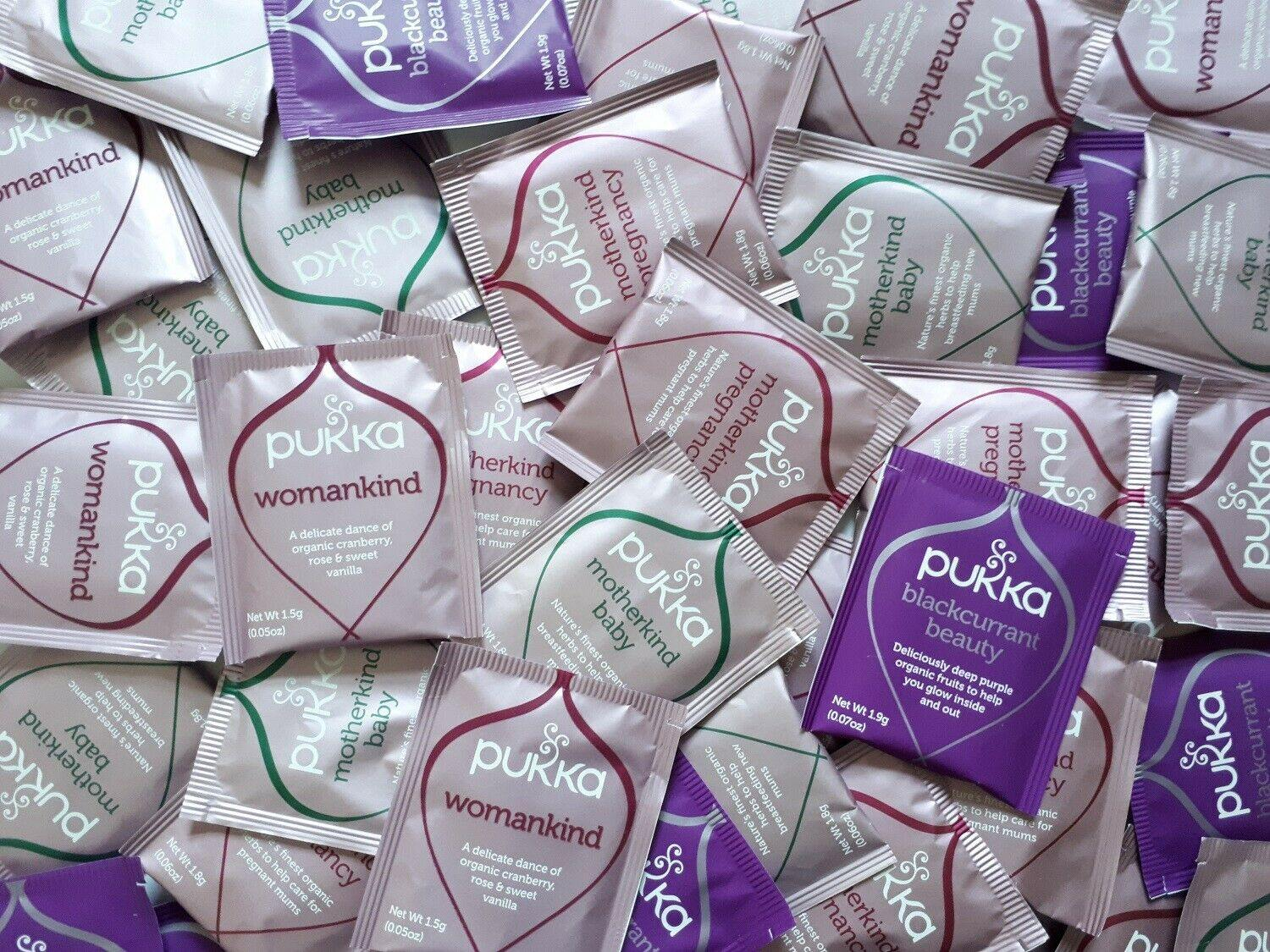Pukka brand health product packets including 'Womankind' and 'Blackcurrant Beauty' on a white background.