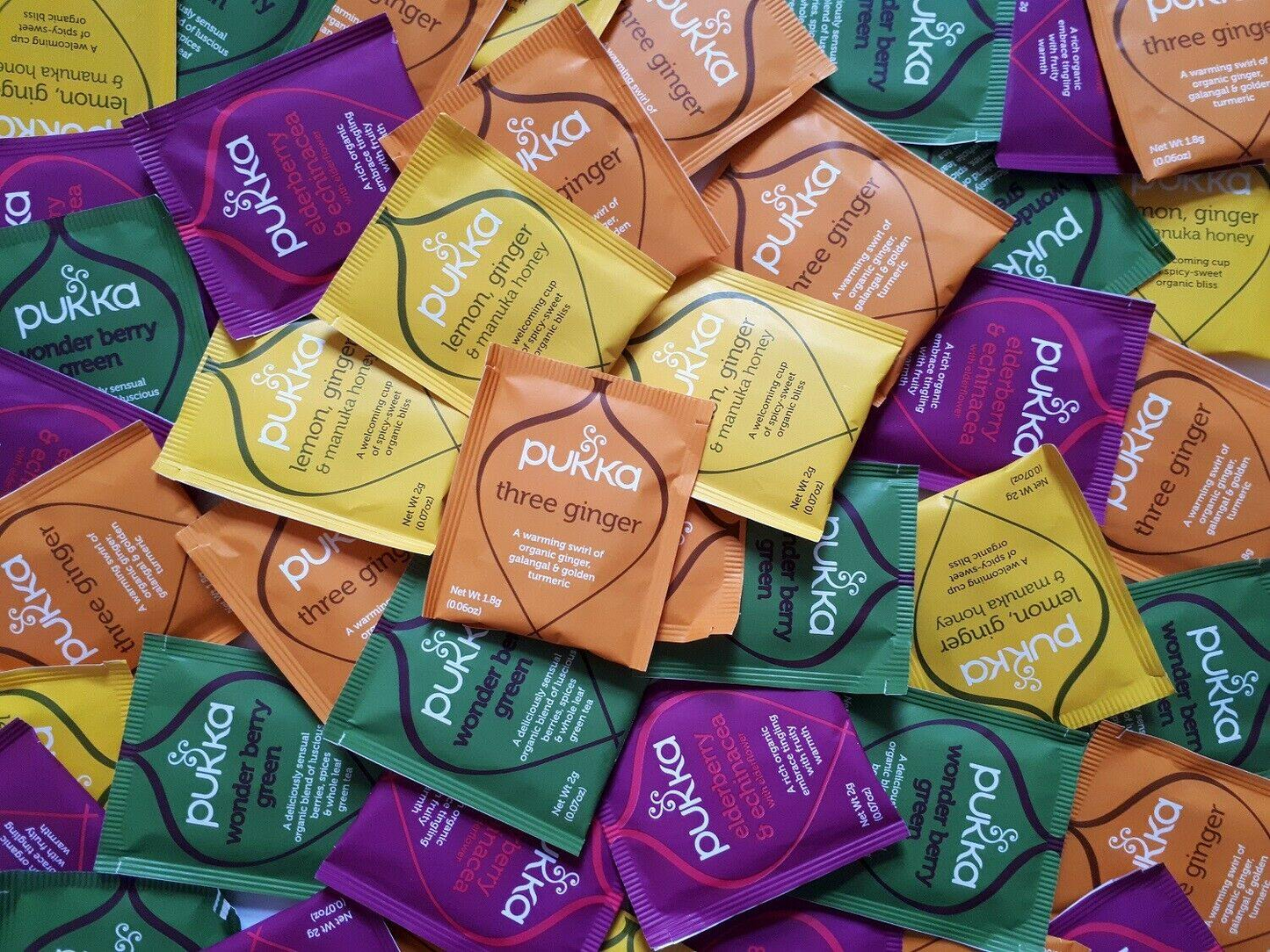 Assorted packets of Pukka tea in various colors and flavors.
