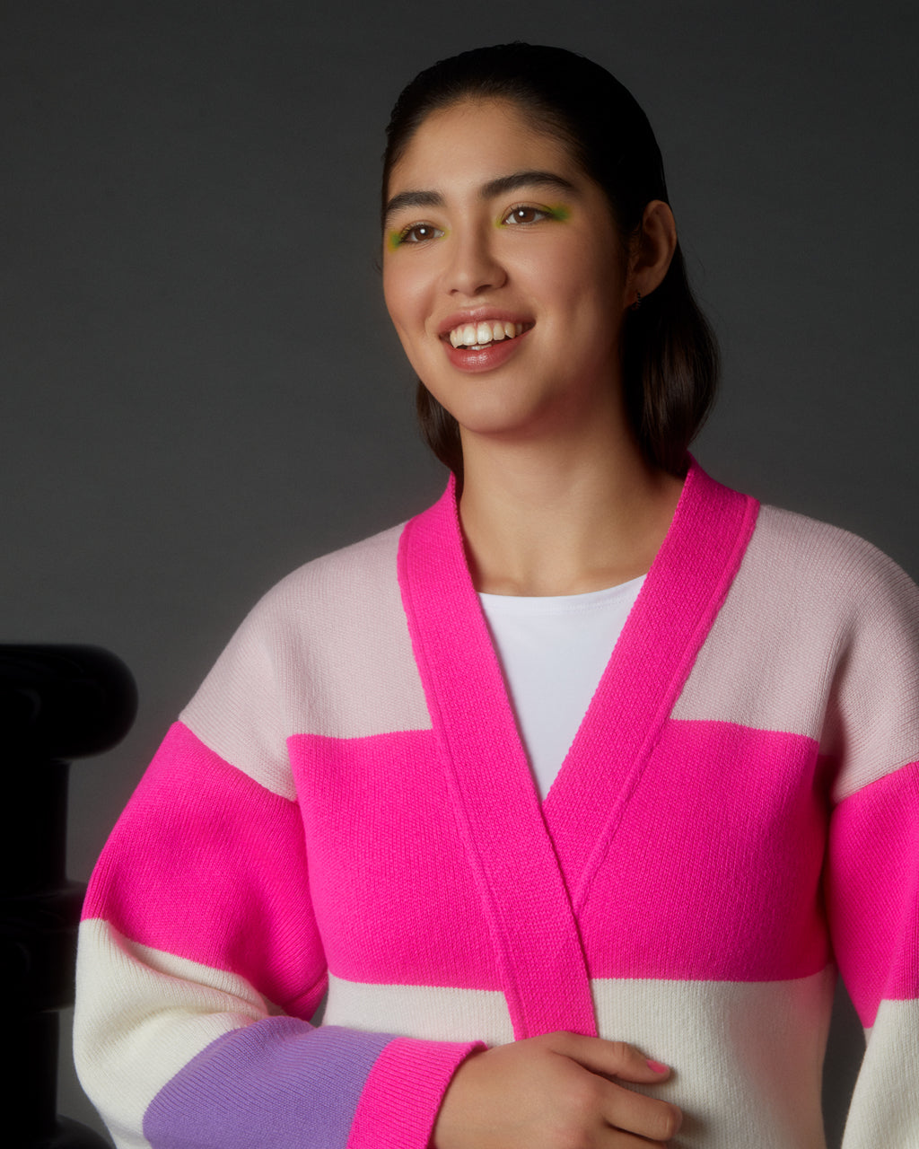 Woman wearing a Luxurious Multicolour Striped Long Cardigan - Wool & Cashmere Blend | Sustainable & Cozy with pink and purple accents on a dark background