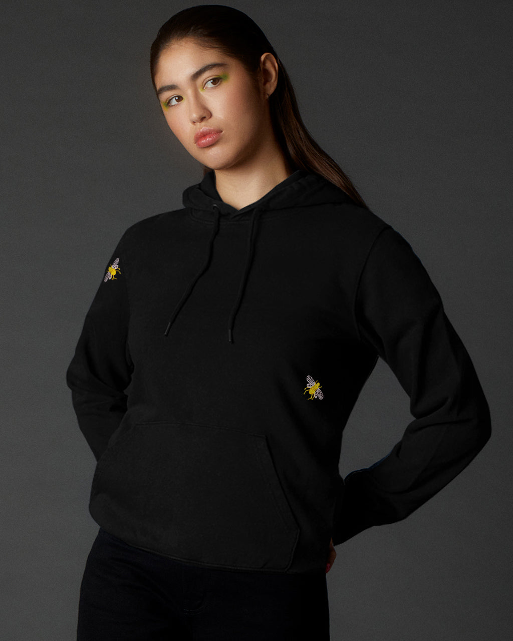 Woman wearing a Bee Embroidered Hoodie Black - Stylish & Comfortable Organic Cotton Hoodie with small yellow bees on a dark background
