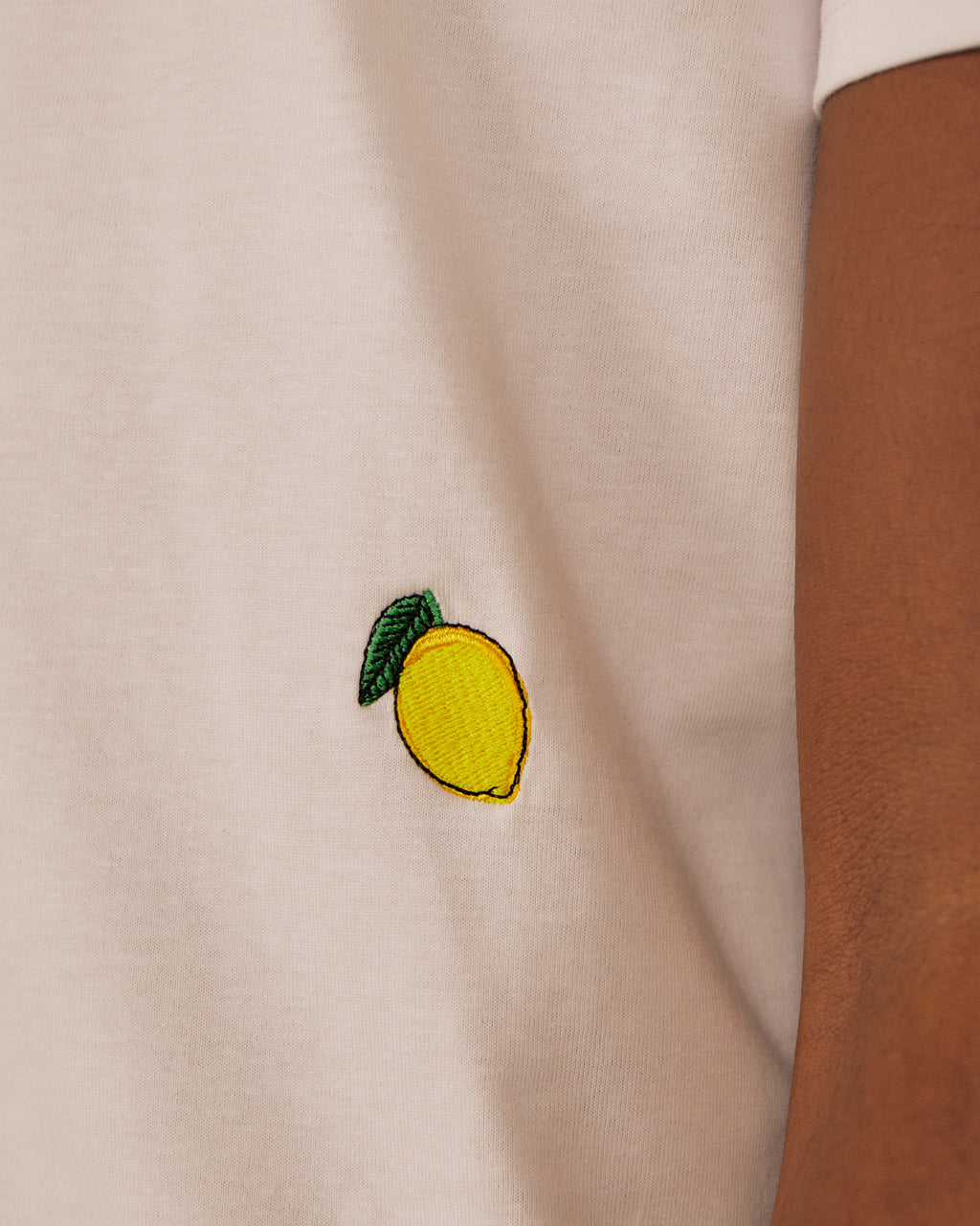 Close up of a emdroidered lemon on a white Organic Cotton T-Shirt | Eco-Friendly & Stylish Crew Neck