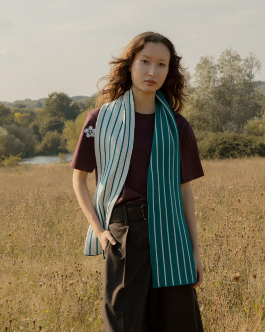 Woman wearing a Luxurious Thin Stripe Wool & Cashmere Scarf in Teal | Soft, Stylish & Ethically Sourced in a field with trees in the background