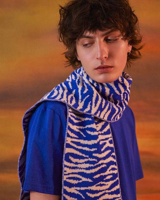 Person wearing a blue and white patterned scarf with a blurred background
