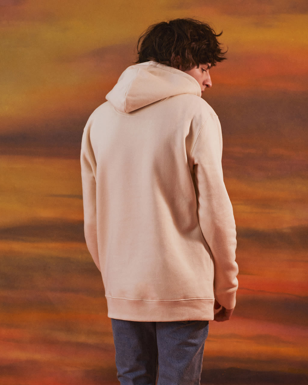 Person wearing a Bee Embroidered Hoodie for Men with a blurred autumn landscape background