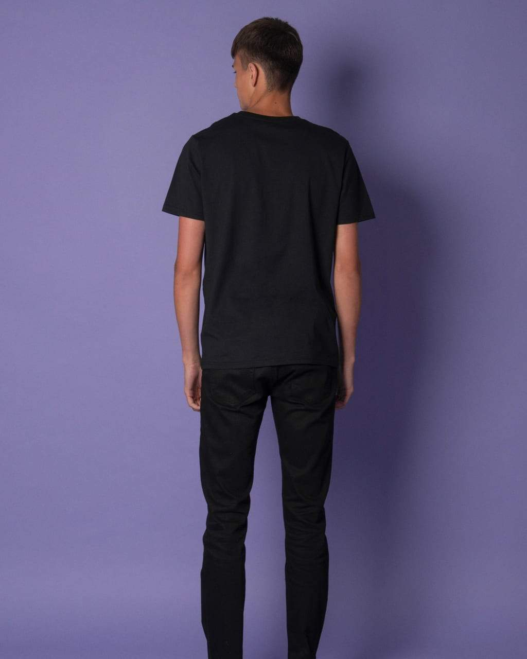 Person wearing a black Bee Embroidered Black T-Shirt and pants against a purple background