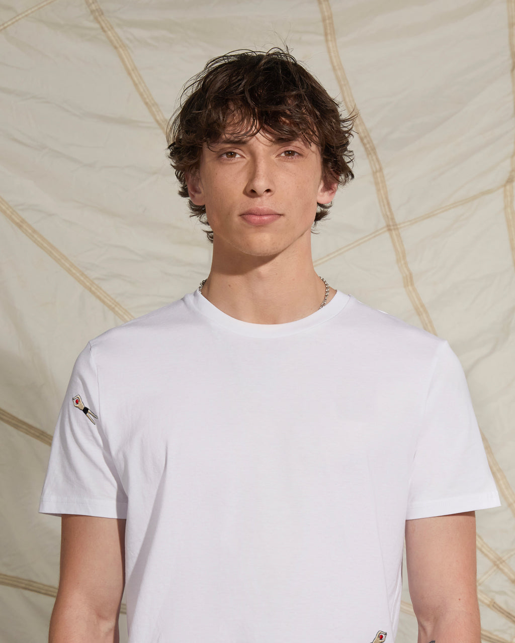 Person wearing a white t-shirt with geometric wall background