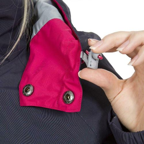 Close-up of a hand adjusting a button on a pink pocket of a dark jacket.