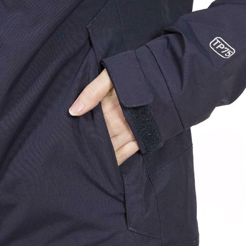 Close-up of a dark blue jacket with a hand in the sleeve pocket, featuring a brand logo.