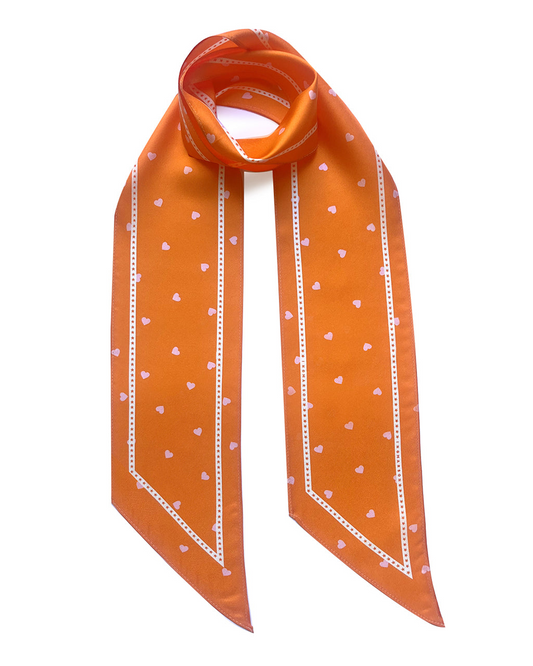 Orange scarf with white heart patterns on a white background