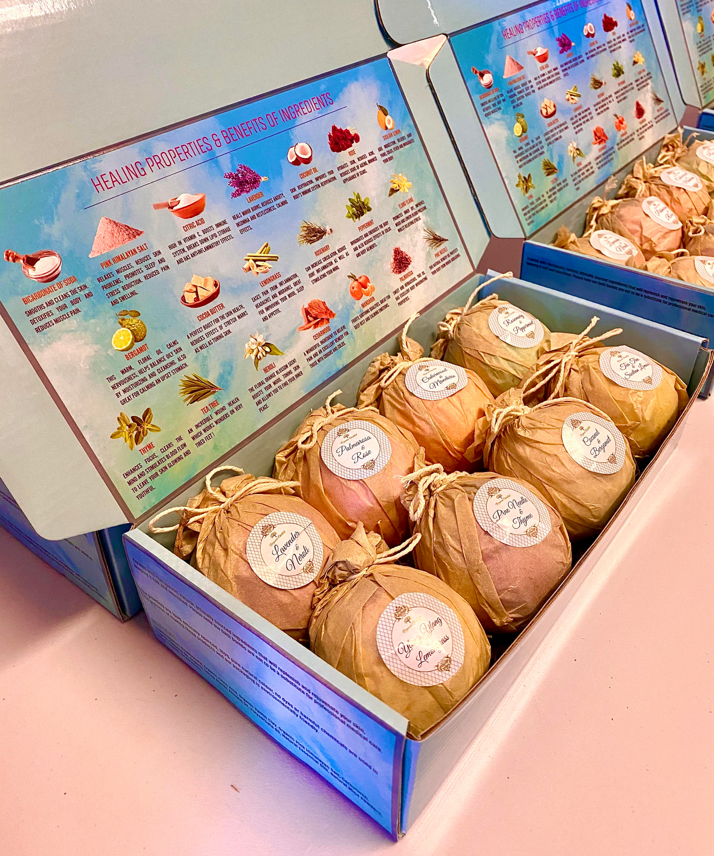 Box of bath bombs with labels in a box and a colorful information sheet on the inside of the box lid.