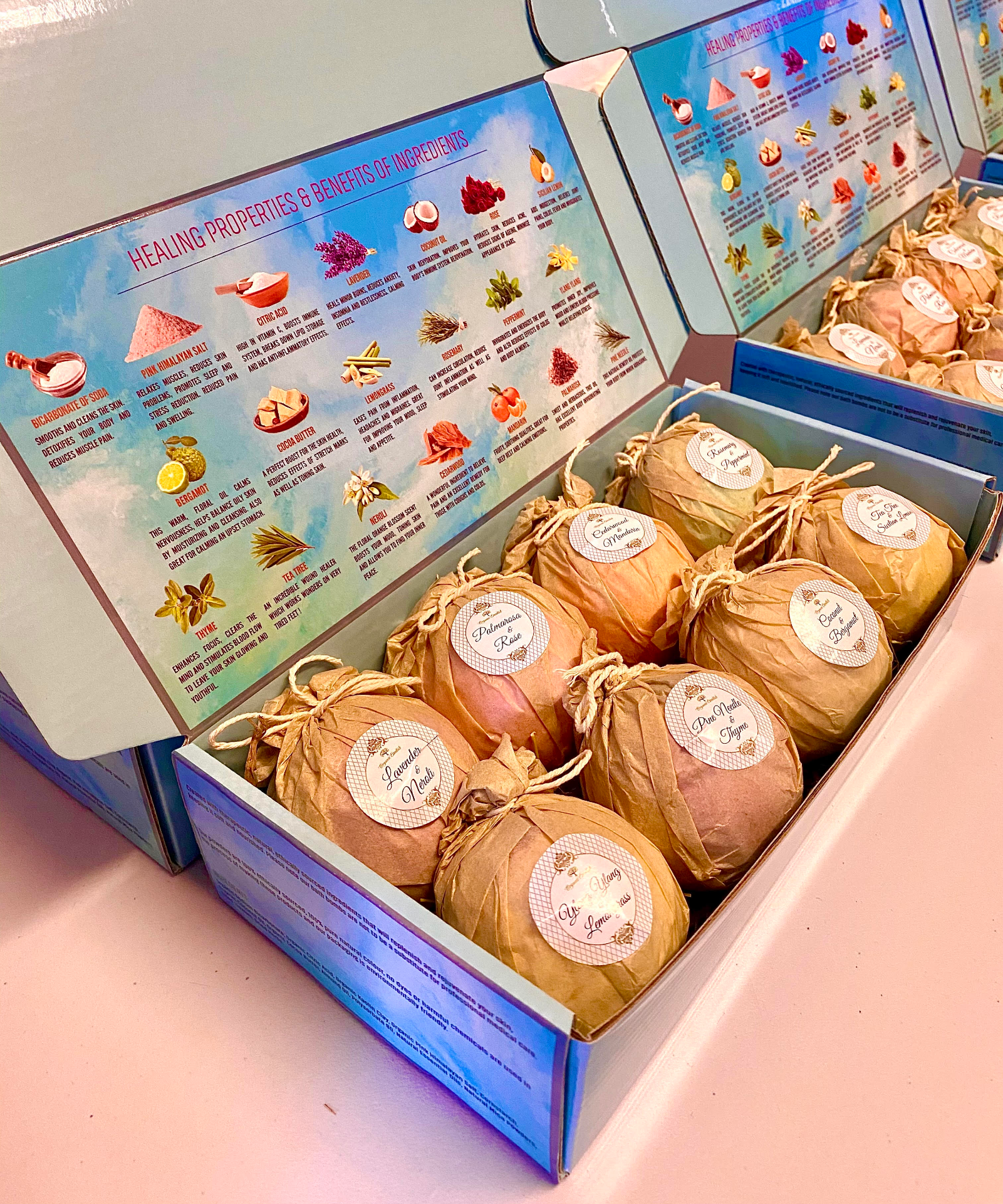 Box of bath bombs with labels in a box and a colorful information sheet on the inside of the box lid.